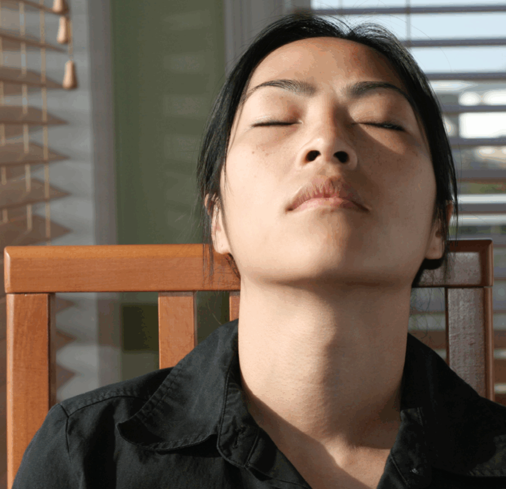 Photo of a person with their eyes closed sitting in a chair