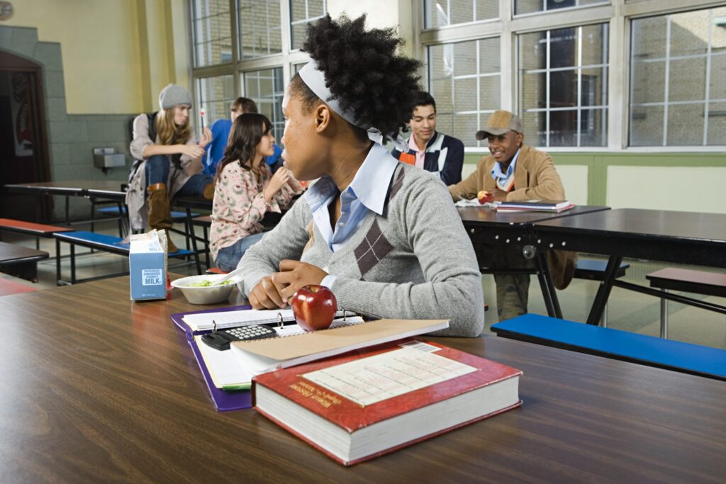 Photo of a young student sitting alone at lunch
