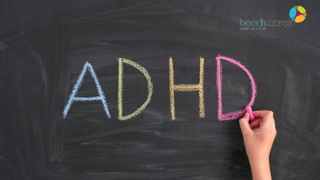 Photo of a child's hand writing ADHD on a chalkboard