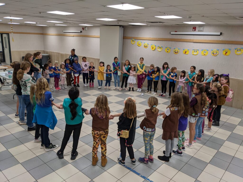 Photo of children standing in a circle as they hold hands