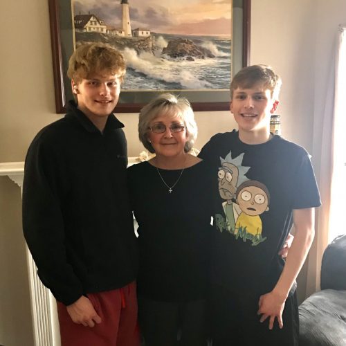 Photo of an elderly woman standing between two teenage boys