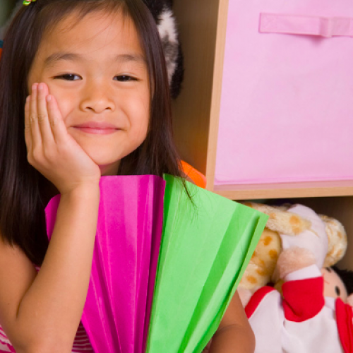 Photo of a young girl sitting in her room and smiling